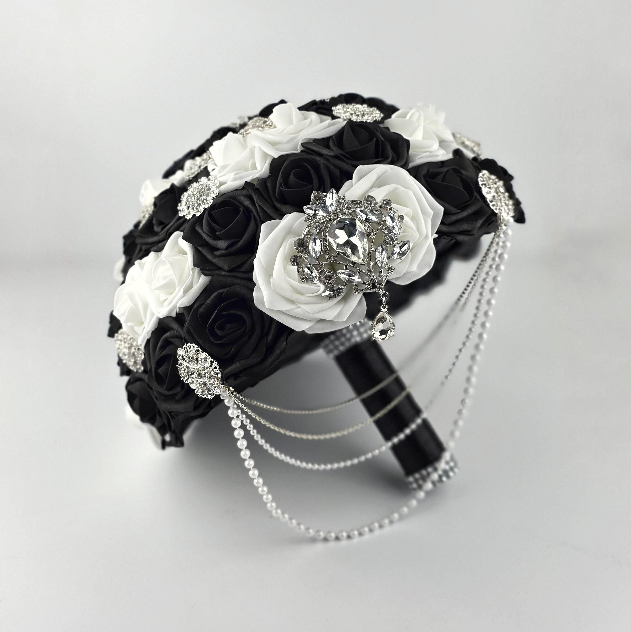 Black and White wedding bouquet with silver brooches and silver and pearl cascade. Black satin ribbon handle and silver bling wrap. Made from Real Touch Roses