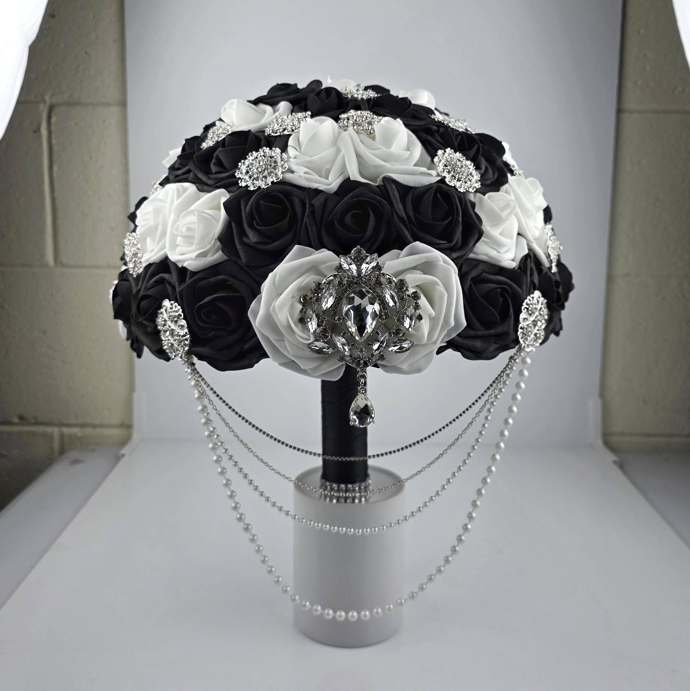 Black and white cascading bouquet with pearl and silver chains. Silver brooches scattered throughout.