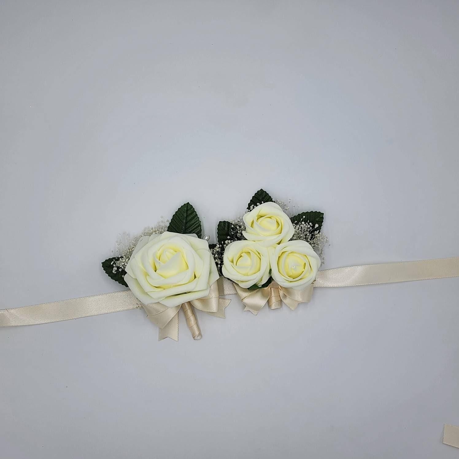 ivory boutonniere and wrist corsage with baby's breath
