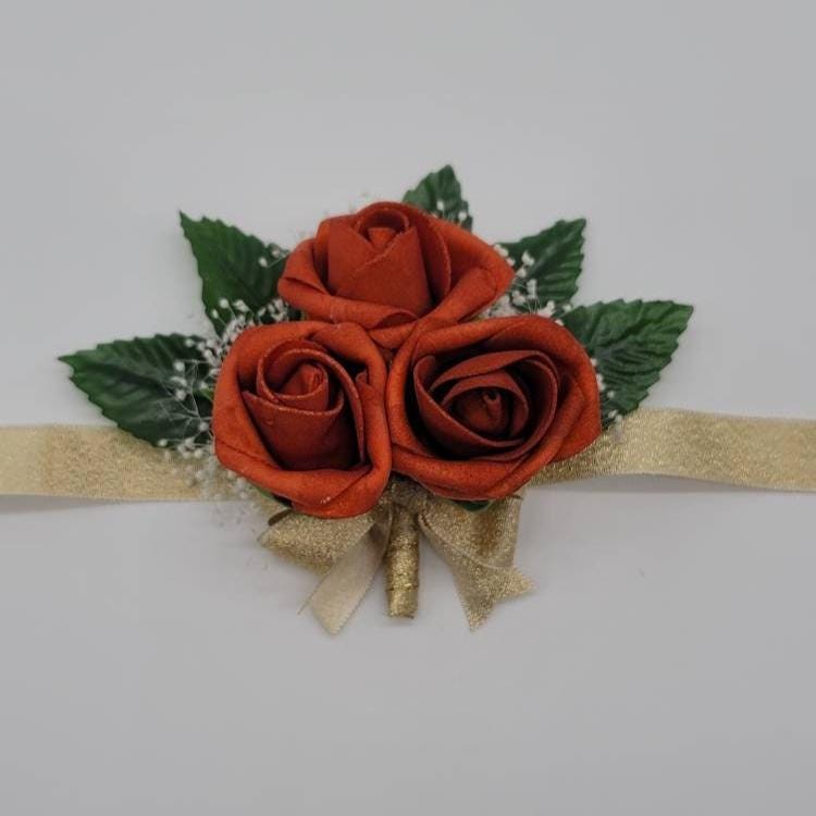 burnt orange and gold wrist corsage with baby's breath