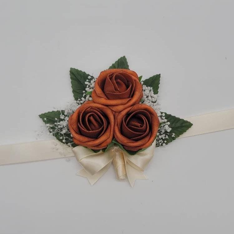 Burnt orange and ivory wrist corsage with baby's breath